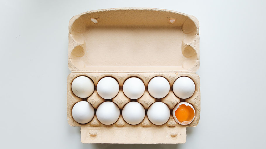 Eggs in an egg carton, one is cracked